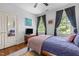 Bedroom with wood floors, large windows providing outdoor views, and a mirrored closet door at 100 Michaels Way, Chapel Hill, NC 27516