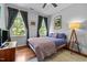Bright bedroom featuring hardwood floors, large windows, and a comfortable bed with stylish bedding at 100 Michaels Way, Chapel Hill, NC 27516