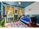 Vibrant bedroom showcasing bold blue accents, colorful rug, and ample natural light from large windows at 100 Michaels Way, Chapel Hill, NC 27516