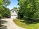 A tree shades a winding driveway leading to an attached two-car garage at 100 Michaels Way, Chapel Hill, NC 27516