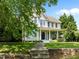 Inviting two-story home featuring a charming porch, well-manicured lawn, and stone front wall at 100 Michaels Way, Chapel Hill, NC 27516