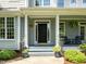 Inviting front porch with decorative plants, furniture, and a welcoming entrance enhancing the curb appeal of the home at 100 Michaels Way, Chapel Hill, NC 27516