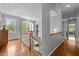 Hallway with hardwood floors, natural light, and an archway overlooking the staircase with white railing at 100 Michaels Way, Chapel Hill, NC 27516