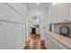 Hallway with hardwood floors, and view into the kitchen featuring white cabinets and appliances at 100 Michaels Way, Chapel Hill, NC 27516