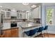 Well-lit kitchen boasting granite countertops, stainless steel appliances, white cabinets, and modern seating at 100 Michaels Way, Chapel Hill, NC 27516