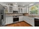 Kitchen featuring white cabinets, granite countertops, stainless steel appliances, and unique glass-front cabinets at 100 Michaels Way, Chapel Hill, NC 27516
