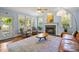 Cozy living room featuring hardwood floors, a fireplace, and multiple windows, offering a warm and inviting atmosphere at 100 Michaels Way, Chapel Hill, NC 27516