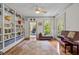 Living room with hardwood floors, built-in bookshelves, a piano, and a view of the home office at 100 Michaels Way, Chapel Hill, NC 27516