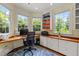 Home office featuring built-in cabinets and desk, providing ample natural light and workspace at 100 Michaels Way, Chapel Hill, NC 27516