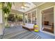 Cozy screened porch with a striped rug, skylights, ceiling fan, and comfortable seating at 100 Michaels Way, Chapel Hill, NC 27516