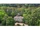 Stunning aerial view of a secluded home surrounded by lush trees and a serene lake, offering privacy at 1009 Bearglades Ln, Raleigh, NC 27615