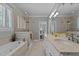 Well-lit bathroom boasts dual sinks, granite countertops, a bathtub, shower, tiled floors, and neutral walls at 1009 Bearglades Ln, Raleigh, NC 27615