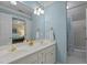 Bright bathroom with double sink, vanity, and shower-tub combo with light blue walls at 1009 Bearglades Ln, Raleigh, NC 27615