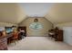 Spacious bonus room features a desk, large oval window and piano, creating a versatile space for relaxation or hobbies at 1009 Bearglades Ln, Raleigh, NC 27615