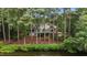 Stunning exterior view of the home from the water, surrounded by mature trees and landscaping at 1009 Bearglades Ln, Raleigh, NC 27615