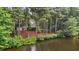 Beautiful view of home from the water, surrounded by trees and landscaping at 1009 Bearglades Ln, Raleigh, NC 27615