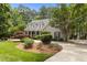 Well-maintained home exterior with a charming front porch, circular driveway, and lush landscaping at 1009 Bearglades Ln, Raleigh, NC 27615
