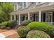 Inviting front porch with white columns, black shutters, and neatly trimmed landscaping at 1009 Bearglades Ln, Raleigh, NC 27615