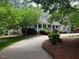 Charming home with mature trees, lush lawn, and inviting covered porch for outdoor enjoyment at 1009 Bearglades Ln, Raleigh, NC 27615
