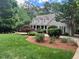 Beautifully landscaped front yard with mature trees, lush lawn, and a charming home exterior at 1009 Bearglades Ln, Raleigh, NC 27615