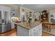 Open kitchen featuring a granite island with seating, stainless steel refrigerator, and custom shelving for ample storage at 1009 Bearglades Ln, Raleigh, NC 27615