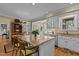 Bright kitchen featuring a granite island, white cabinets, stainless steel appliances, and natural light from large windows at 1009 Bearglades Ln, Raleigh, NC 27615