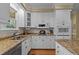 Well-equipped kitchen featuring white cabinetry, granite countertops, stainless steel appliances, and modern fixtures at 1009 Bearglades Ln, Raleigh, NC 27615