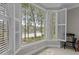 Inviting seating area showcases scenic views of a serene lake through shuttered windows at 1009 Bearglades Ln, Raleigh, NC 27615