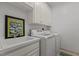 Clean laundry room featuring white cabinets, sink, washer and dryer at 1009 Bearglades Ln, Raleigh, NC 27615