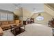 Spacious bonus room with brown sofa, coffee table, desk, and oval window at 1009 Bearglades Ln, Raleigh, NC 27615