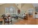 Bright living room featuring hardwood floors, vaulted ceilings, and a view into the dining room and kitchen at 1009 Bearglades Ln, Raleigh, NC 27615