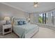 Bright main bedroom featuring plush carpet, neutral walls, white trim, and stunning lake views through shuttered windows at 1009 Bearglades Ln, Raleigh, NC 27615