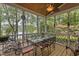 Covered outdoor dining area with ceiling fan, table and seating overlooking lake and natural landscaping at 1009 Bearglades Ln, Raleigh, NC 27615