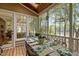 Covered outdoor dining area with table and seating with views of lake and natural landscaping at 1009 Bearglades Ln, Raleigh, NC 27615