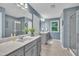 Modern main bathroom featuring double sinks, gray cabinetry, and a tile shower at 1022 Flagler St, Durham, NC 27713