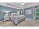 Bright main bedroom with cool blue walls, plush carpeting, and a modern ceiling fan at 1022 Flagler St, Durham, NC 27713