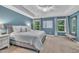 This is a spacious main bedroom with blue walls, carpet floors, and a ceiling fan at 1022 Flagler St, Durham, NC 27713
