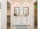 This modern bathroom features double sinks, a marble countertop, modern lighting, and white shaker cabinets at 103 Harrington Pt, Chapel Hill, NC 27516