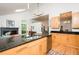 This kitchen features sleek wood cabinets, black granite countertops, stainless steel appliances, and hardwood floors at 103 Harrington Pt, Chapel Hill, NC 27516
