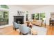 Bright living room with hardwood floors, a fireplace, and large windows offering scenic views at 103 Harrington Pt, Chapel Hill, NC 27516