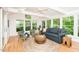 Bright sunroom features lots of natural light, wood floors, and comfortable seating to enjoy the wooded landscape at 103 Harrington Pt, Chapel Hill, NC 27516