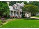 Beautifully landscaped two-story home with a well-manicured lawn, charming porch, and lush greenery at 107 Ivy Hollow Ct, Morrisville, NC 27560