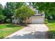 Front exterior of house with well-maintained lawn, brick walkway, and mature trees at 107 Ivy Hollow Ct, Morrisville, NC 27560