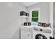 Functional laundry room with washer, dryer, and storage shelves for organization at 107 Ivy Hollow Ct, Morrisville, NC 27560