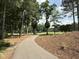 Scenic paved path winding through a lush, wooded landscape, perfect for leisurely strolls at 107 Ivy Hollow Ct, Morrisville, NC 27560