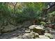 Secluded backyard garden featuring unique stone benches and dining, surrounded by a tranquil landscape at 107 Silo Dr, Chapel Hill, NC 27514