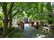 Beautiful backyard featuring a charming red bridge with stone landscaping and mature trees at 107 Silo Dr, Chapel Hill, NC 27514