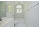Clean bathroom with white tile floor, white cabinets and bath tub under window at 107 Silo Dr, Chapel Hill, NC 27514