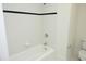 White tiled shower and tub combination with black accent stripe and a toilet at 107 Silo Dr, Chapel Hill, NC 27514