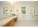 Well-lit bathroom with double windows, spacious vanity, and neutral-toned tile flooring at 107 Silo Dr, Chapel Hill, NC 27514